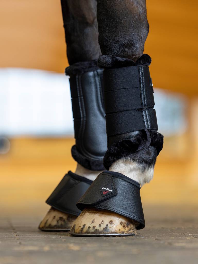 LeMieux WrapRound Leather Over Reach Boots Black. LeMieux zwarte springschoenen met verstelbare WrapRound-sluiting en dubbele secure-lock. Perfect voor training, warming-up en transport. Shop bij Livin Horse Shop! Dealer van LeMieux